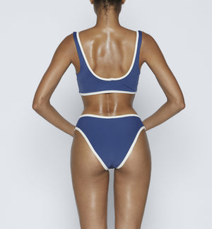 Swimwear Top. Pullover bikini sport bra style top  in dark Blue with Off White contrast binding outline. Bikini bottom. Mid to High Waisted Swimwear bottom in Dark Blue with Off White. Medium to full coverage bikini bottom. High Legs swimsuit bottom. Check out our fashion boutique swimsuit online shop. supper soft fabric Nylon/spandex. sport bikini