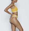 Swimwear Top. Pullover bikini sport bra style top  in vintage yellow with White contrast binding outline. Bikini bottom. Mid to High Waisted Swimwear bottom in yellow vintage with White binding outline. Medium to full coverage bikini bottom. High Legs swimsuit bottom. Check out our fashion boutique swimsuit online shop. supper soft fabric Nylon/spandex. sport bikini